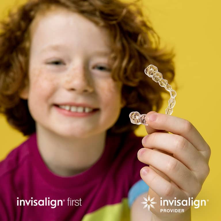 Child shows Invisalign product in hand in Brampton