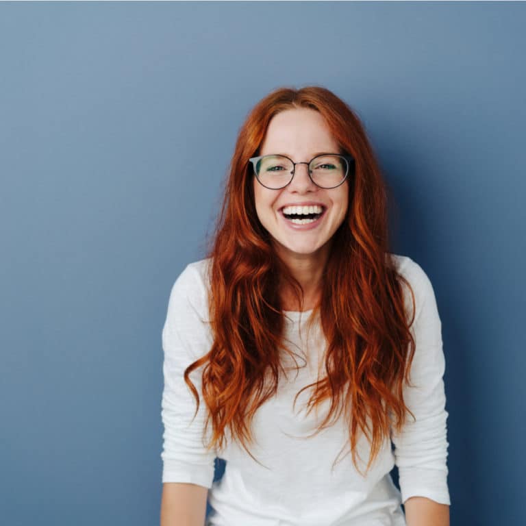 Woman smiling after receiving Invisalign treatment in Brampton